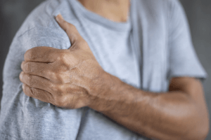 man holding his shoulder in pain