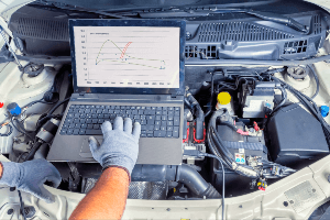 mechanic looking at black box data on laptop