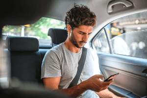 Passenger in a vehicle checking his phone