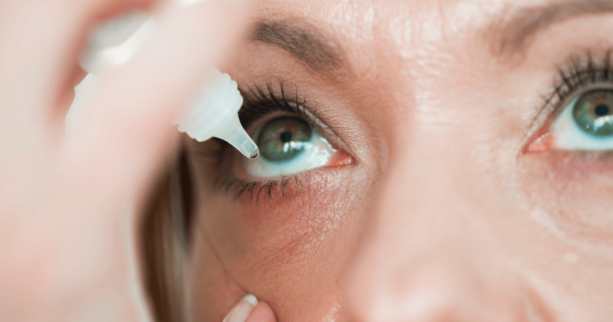 Woman putting eye drops in her eye