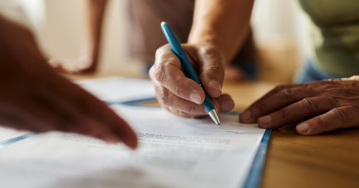 close-up stock image of a hand signing a document
