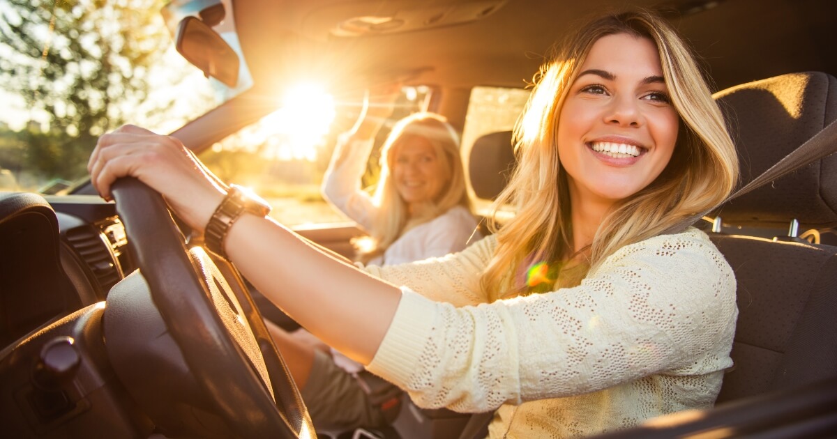 female teen driver in car with mom on a sunny day in California